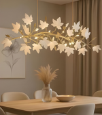 Floral chandelier hanging above a dining table with a vase and bowl on the table.