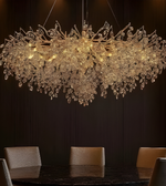 Luxurious chandelier hanging above a dining table with chairs in a dimly lit room.