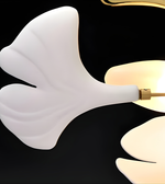 Modern wall sconce with white ceramic shade and gold fixture on a black background