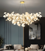 Modern chandelier hanging in a living room with a sofa and wall art.