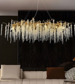 Luxurious chandelier hanging above a modern living room with a black wall.