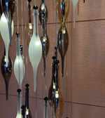 Decorative glass pendant lights hanging against a tiled wall.