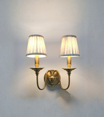 Pair of wall sconces with lampshades on a plain wall