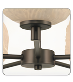 Close-up of a ceiling fan with bronze finish and glass shades.