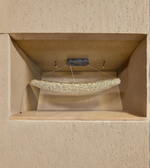 Decorative stone shelf with a small decorative object on a beige wall.