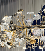Luxury chandelier with gold and crystal elements on a reflective surface.