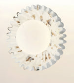 A circular white wall sconce with a scalloped, fluted outer rim and a smooth central dome, shown against a plain light background.
