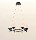 A modern 5-light chandelier with a glossy black circular metal frame, textured white glass shades, and a black ceiling canopy, shown against a plain light beige background.