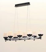 A modern 8-light linear chandelier with textured frosted glass shades and black metal accents, suspended from a rectangular ceiling mount against a plain off-white background.