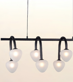 Modern black metal chandelier with six curved arms and frosted white globe shades, shown against a plain light background.