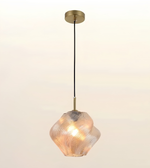 A modern pendant light with a textured, ribbed clear glass shade that glows warm when lit, suspended by a black cord from a round brass ceiling canopy.