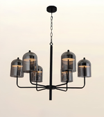 A modern six-light chandelier with a matte black metal frame and smoked glass bell shades, shown against a plain light beige background.