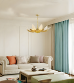 Modern living room with a gold chandelier, beige sofa, and decorative items.