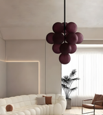 Modern living room with a white sofa, decorative pillows, and a stylish purple pendant light.