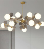 Modern chandelier with white glass bulbs and gold metal accents on a neutral background