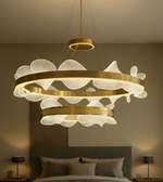 Decorative chandelier hanging above a bed in a bedroom setting.