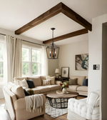 Living room with beige sofa, white armchair, and wooden beams on the ceiling.