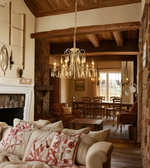 Cozy living room with a chandelier, fireplace, and floral-patterned pillows.