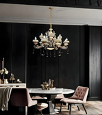 Dining room with a chandelier, table, and chairs against a dark wall.