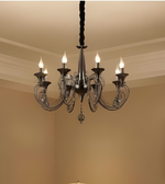 Chandelier hanging from the ceiling in a room with beige walls.