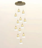 A modern multi-light linear chandelier with a brushed gold circular ceiling canopy and twelve cascading frosted glass cone shades, shown against a plain light beige background.