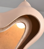 Close-up of a modern pendant light with a unique design on a gray background