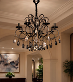 Detailed view of a luxury black chandelier featuring curved metal arms and cascading crystal accents.