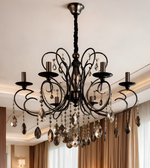 Black metal crystal chandelier featuring curved scrollwork arms, decorative candle-style light holders, and cascading faceted crystal drops.