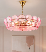 Pink circular disc chandelier with layered translucent discs, a golden suspension chain, and a sculptural contemporary design.