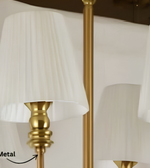 Close-up of the gold-tone metal chandelier frame and cream pleated lampshade, showcasing its decorative finish and detailing.
