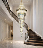 Royal glass spiral cascade staircase chandelier with warm lighting in a grand luxury interior
