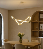 Geometric LED dining pendant light hanging above a dining table in a modern interior