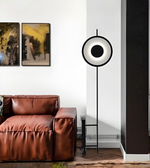 Contemporary ring-shaped LED standing lamp beside sofa in living room