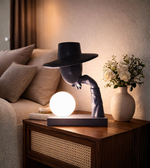 Modern sculptural table lamp with human figure design and glowing orb light for luxury interior décor