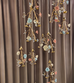 Decorative hanging floral arrangements with gold accents against a brown curtain background