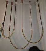 Rope swing hanging from the ceiling against a white wall