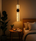 Modern crystal pendant light above nightstand in cozy bedroom with neutral decor