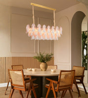 Elegant glass petal dining chandelier with warm lighting above a modern dining table interior