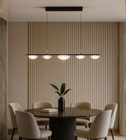 Modern frosted acrylic pendant with four diffusers hanging above a luxury dining table in beige tones