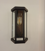 Modern black metal and glass outdoor wall light with decorative E27 bulb mounted on an exterior wall