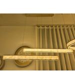 Modern linear pendant light fixtures with a warm cream imitate marble-look finish and gold-toned trim.