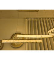 Modern linear pendant light fixtures with a warm cream imitate marble-look finish and gold-toned trim.