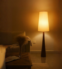 Scandinavian-style wooden floor lamp with warm fabric shade illuminating a cozy living room corner.