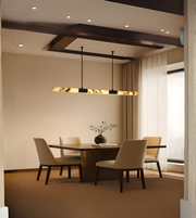 Long marble-effect linear chandelier hanging above elegant beige dining table setup.