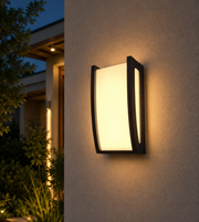 Modern black 30W LED outdoor wall light with warm 3000K illumination mounted on an exterior wall