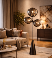 Modern smoked glass cluster floor lamp with black stand placed beside sofa in contemporary living room