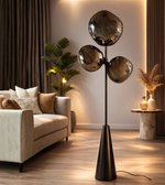 Modern smoked glass cluster floor lamp with black stand placed beside sofa in contemporary living room