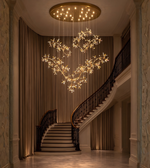 Luxury crystal blossom chandelier with gold branches installed in double height staircase area
