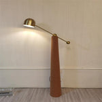Tall designer floor lamp with brass arm and leather-finish base