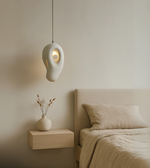 Elegant white sculptural pendant light in organic shape, minimalist foam ceiling lamp for bedrooms, cafes and modern interiors.